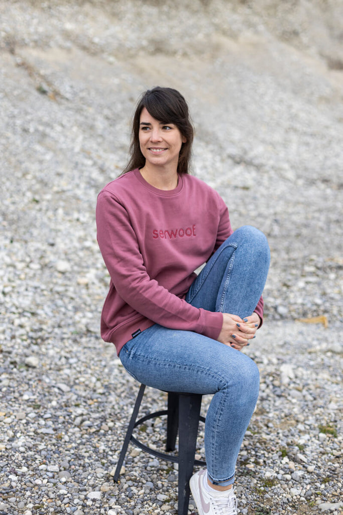Frau, sitzend, im serwoof Sweater in der Farbe hibiskus